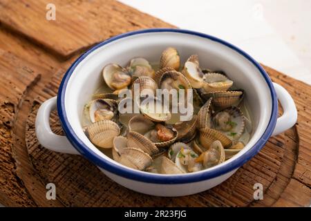 Cockles mit grünem Knoblauch und Petersiliensoße. Traditionelle spanische Fischtapa. Stockfoto