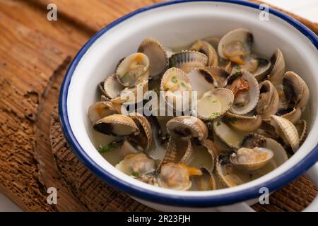 Cockles mit grünem Knoblauch und Petersiliensoße. Traditionelle spanische Fischtapa. Stockfoto