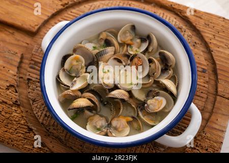 Cockles mit grünem Knoblauch und Petersiliensoße. Traditionelle spanische Fischtapa. Stockfoto