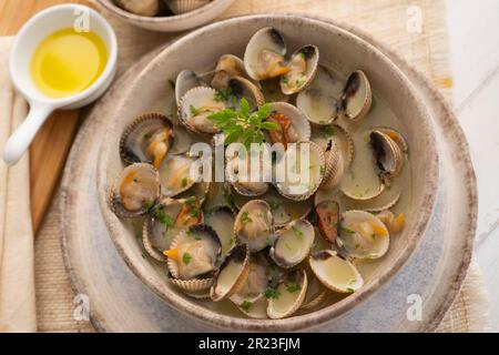 Cockles mit grünem Knoblauch und Petersiliensoße. Traditionelle spanische Fischtapa. Stockfoto