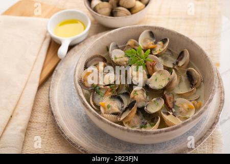 Cockles mit grünem Knoblauch und Petersiliensoße. Traditionelle spanische Fischtapa. Stockfoto