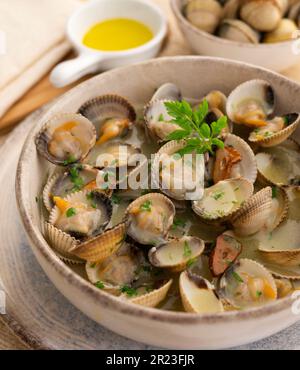 Cockles mit grünem Knoblauch und Petersiliensoße. Traditionelle spanische Fischtapa. Stockfoto