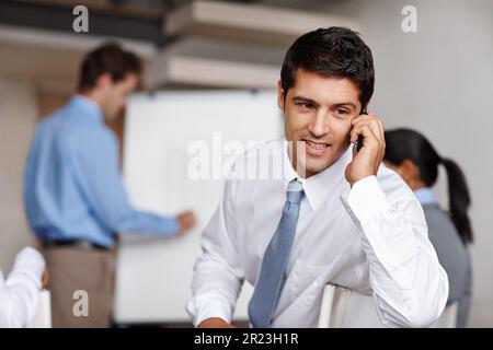 Ich sage dir, wir müssen verkaufen. Ein wütender junger Manager, der während einer Geschäftspräsentation einen Anruf entgegennimmt. Stockfoto