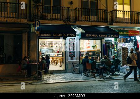 Leute, die nachts in Lissabon spazieren gehen. Portugal - Mai 2023. Hochwertiges Foto Stockfoto