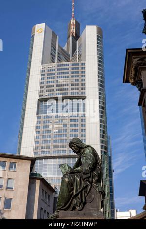 17. Mai 2023, Hessen, Frankfurt/M.: Eine Figur des Johannes Gutenberg-Denkmals am Rossmarkt, mit dem Firmensitz der Commerzbank im Hintergrund. Mit einem Überschuss von 580 Millionen Euro verdiente die Commerzbank im ersten Quartal fast doppelt so viel wie ein Jahr zuvor. Foto: Helmut Fricke/dpa Stockfoto