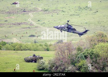 Hammelburg, Deutschland. 16. Mai 2023. Ein Tiger-Angriffshubschrauber fliegt über einem „Boxer“ während der Militärübung, die anlässlich des Eröffnungsbesuchs des deutschen Verteidigungsministers Pistorius an der Hammelburger Infanterieschule stattfindet. Kredit: Daniel Löb/dpa/Alamy Live News Stockfoto