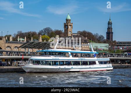Hamburg, Deutschland - 04 17 2023:Blick vom Wasser der hamburger Landungsbrücken mit einem Vergnügungsboot und der Kirche St. Michaelis im Hintergrund Stockfoto
