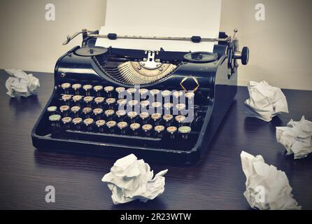 Klassische Schreibmaschine mit zerknittertem Papier auf dem Tisch Stockfoto