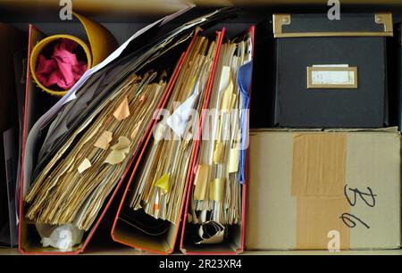 Unordentliche Aktenordner, Bürokratie, Bürokratie, Abfertigung, Geschäftskonzept. Analoge Filmfarben im Vintage-Look. Stockfoto