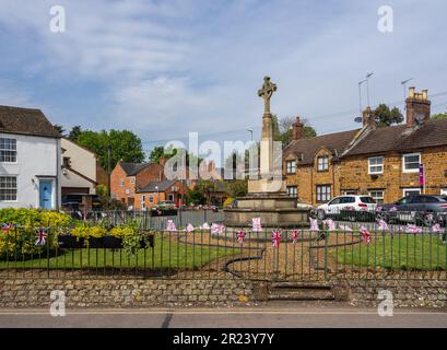 Village Green mit Kriegsdenkmal und Union Jack Bunting, Hardingstone, Northampton, Großbritannien Stockfoto