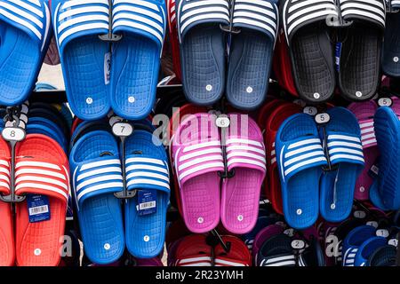 Farbenfrohe Strandsandalen auf einem Gestell in Cornwall im Vereinigten Königreich. Stockfoto