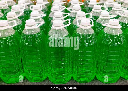 Grüne technische Flüssigkeit in Plastikflaschen im Supermarkt. Stockfoto