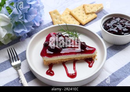 Blaubeerkäsekuchen in weißem Teller mit Rosmarin und einigen Zutaten Stockfoto