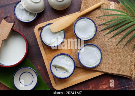 Kanom Tuay: Thailändisches Dessert aus gedämpftem Pandan und Kokosmilch in Keramikbechern von oben Stockfoto