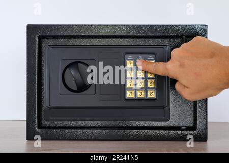 Handtaste am digitalen Sicherheitsschloss mit codiertem Passwort – kleine Hotel- oder Heimsicherheit Stockfoto