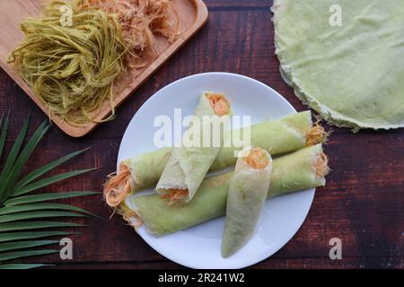 Roti Saimai: Thailändisches Dessert aus Zuckerwatte-Burrito-Pfannkuchen oder Crepes mit Blick auf den Holztisch Stockfoto