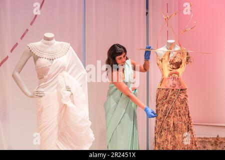London, Großbritannien. 17. Mai 2023. Priya Khanchandani (Kurator) des Design Museums stellt das Herzstück ein, ein wunderschönes goldenes Sabyasachi-Design, das Sari 2022 zum ersten Mal zur Met Gala getragen hat. „The Offbeat Sari“ ist die erste große britische Ausstellung über den zeitgenössischen Sari, mit 60 atemberaubenden Saris auf der Disla im Design Museum, Kensington. Die Ausstellungen werden vom 19. Mai bis 17. September 2023 ausgestellt. Kredit: Imageplotter/EMPICS/Alamy Live News Stockfoto
