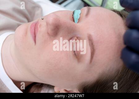 Großaufnahme Von Weißer Frau Mit Laminierender Augenbraue, Gerolltem Haar Auf Silikonrollen. Locken, Färben, Verlängerungsverfahren Für Lashes. Horizontal Stockfoto