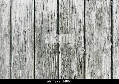 Nahaufnahme einer alten schäbigen Holzplanke mit gerissener grauer Farbe. Rustikaler Hintergrund oder Textur. Stockfoto