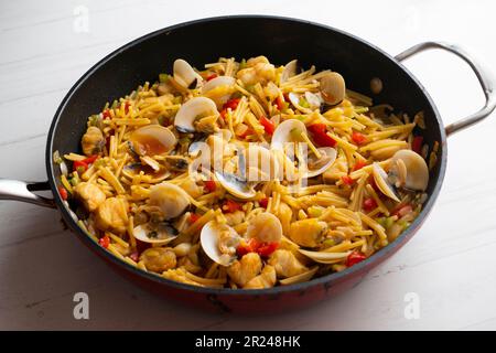 Fideua Paella mit Schalentieren, Seeteufel und Muscheln. Traditionelles spanisches Rezept. Stockfoto