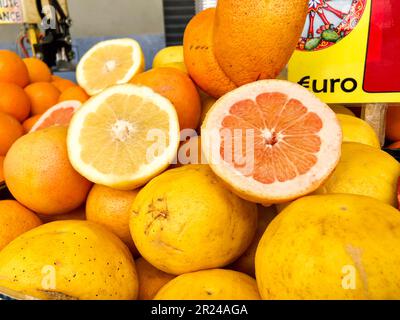 Zitronen, Grapefruits, Orangen in zwei Hälften geschnitten im Obstladen. Zitrusstand auf dem Markt Stockfoto