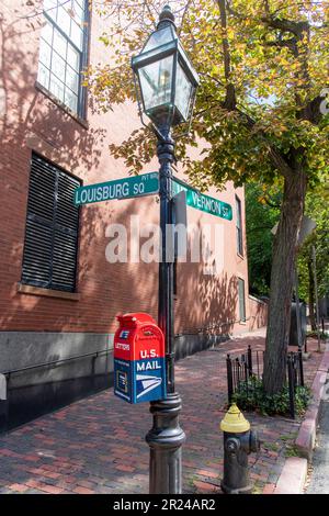 Boston, MA, USA-August 2022; Blick auf eine Straßenlaterne im Retro-Stil mit Straßenschildern an der Ecke Louisburg Square und Vernon Street Stockfoto