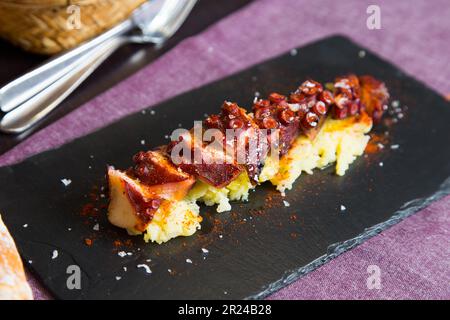 Pulpo a la Gallega. Tintenfisch gekocht mit gekochter Kartoffel, Paprika und Olivenöl. Galicisches Tintenfisch-Rezept nördlich von Spanien Tapa. Stockfoto