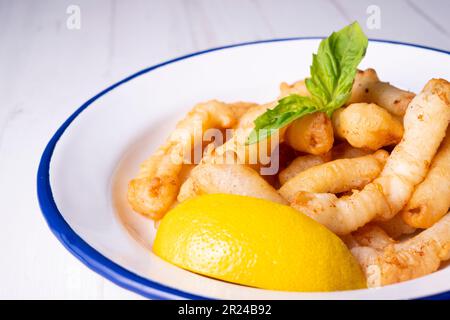 Rabas a la romana panierte Tintenfischbein Tapa serviert mit Zitrone. Traditionelle spanische Tapa. Stockfoto