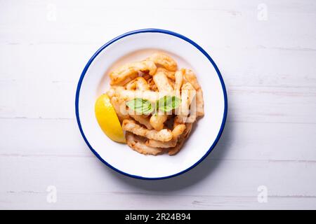 Rabas a la romana panierte Tintenfischbein Tapa serviert mit Zitrone. Traditionelle spanische Tapa. Stockfoto