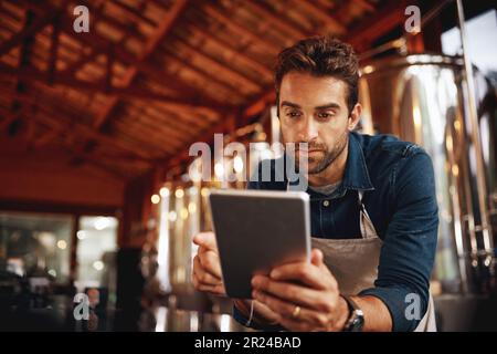 Tablet, Focus und Brauerei mit man in der Fabrik für Produktion, Herstellung und Alkoholfermentation. Technologie, Inspektion und digitale Kommunikation mit Unternehmen Stockfoto