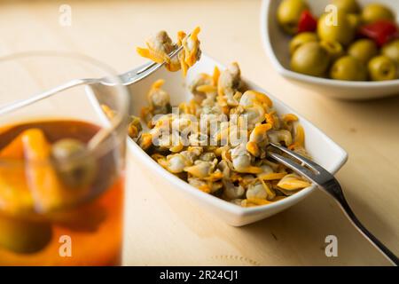 Vermouth ist ein in Kräutern mazerierter Wein, der als Aperitif mit Cockeln, Sardellen, Oliven oder Muscheln eingenommen wird. Stockfoto