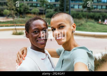 Zwei Geschäftsfrauen machen Selfies im Gewerbepark Stockfoto