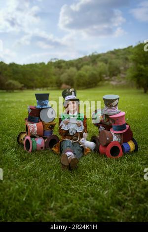 Schöne Frau wie verrückter Hutmacher mit Hüten in der Natur Stockfoto