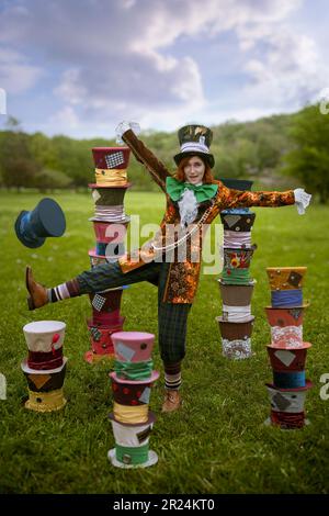 Schöne Frau wie verrückter Hutmacher mit Hüten in der Natur Stockfoto