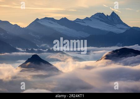 Blick auf die Westseite der Glockner Group. Berggipfel Großglockner. Wolken, Sonnenlicht bei Sonnenaufgang. Österreichische Alpen. Europa. Stockfoto