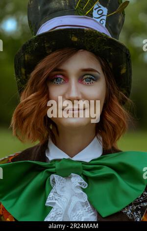 Schöne Frau wie verrückter Hutmacher mit Hüten in der Natur Stockfoto