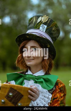 Schöne Frau wie verrückter Hutmacher mit Hüten in der Natur Stockfoto