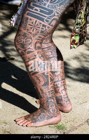 Französisch-Polynesien, Gesellschaftsinseln, Raiatea. Dorfältester mit traditionellen Tattoos bedeckt. Tätowierung am Bein. Stockfoto