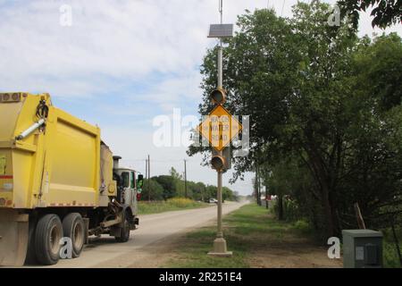 San Antonio, USA. 16. Mai 2023. Ein Müllwagen fährt am 16. Mai 2023 an einem Hochwasser-Alarmsystem auf der Covel Road in San Antonio, Texas, USA vorbei. STOP (High Water Alert Liretsaving Technology) ist ein System, das einen Sensor verwendet, um ansteigendes Wasser zu erkennen. Sobald das Wasser eine bestimmte Wassertiefe erreicht hat, warnt das System den Fahrer. Das System sendet außerdem Echtzeitinformationen an eine Website, sodass Fahrer sehen können, welche Straßen sicher zu fahren sind. (Foto: Carlos Kosienski/Sipa USA) Guthaben: SIPA USA/Alamy Live News Stockfoto