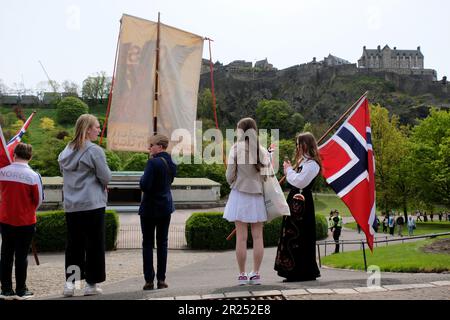 Edinburgh, Schottland, Großbritannien. 17. Mai 2023 Organisiert vom Generalkonsulat der Königlichen Norwegischen Republik, wird dieses Jahr der Tag der norwegischen Verfassung gefeiert, mit einer Parade und einem marsch von der Cockburn Street entlang der High Street, die am Gedenkstein in den Princes Street Gardens mit einer Zeremonie endet. In den Princes Street Gardens, vor dem Ross Bandstand mit dem Schloss. Kredit: Craig Brown/Alamy Live News Stockfoto