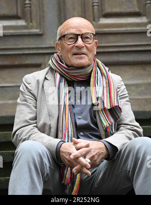 Wiesbaden, Deutschland. 17. Mai 2023. Direktor Volker Schlöndorff sitzt vor Beginn einer Pressekonferenz für die Ausstellung „Volker Schlöndorff. Von Wiesbaden in die Welt' auf einer Treppe der Marktkirche. Die Ausstellung auf der FilmBühne Caligari zeigt Publikationen und Filmserien über das Leben und Werk des preisgekrönten Filmemachers vom 19. Mai bis 18. Juni 2023. Kredit: Arne Dedert/dpa/Alamy Live News Stockfoto