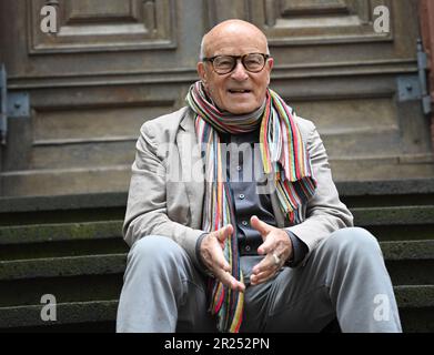 Wiesbaden, Deutschland. 17. Mai 2023. Direktor Volker Schlöndorff sitzt vor Beginn einer Pressekonferenz für die Ausstellung „Volker Schlöndorff. Von Wiesbaden in die Welt' auf einer Treppe der Marktkirche. Die Ausstellung auf der FilmBühne Caligari zeigt Publikationen und Filmserien über das Leben und Werk des preisgekrönten Filmemachers vom 19. Mai bis 18. Juni 2023. Kredit: Arne Dedert/dpa/Alamy Live News Stockfoto