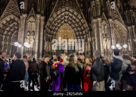 Bild vom Eingang zum kölner Dom mit Menschen, die während des kölner Karnevals vor ihm tanzen. Der Kölner Dom ist katholisch Stockfoto