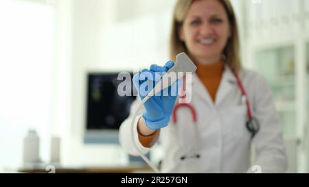 Lächelnde Ultraschallärztin, die den Schallkopf in der klinischen Nahaufnahme hält Stockfoto