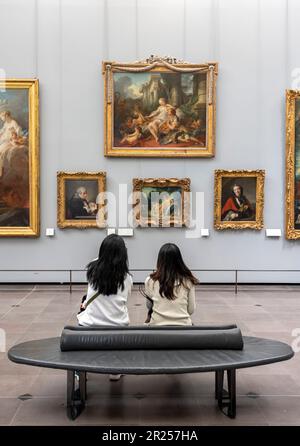 Paris, Frankreich - 05 13 2023: Louvre Museum. Leute von hinten sitzen und schauen sich Gemälde im Museum an Stockfoto