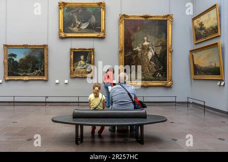 Paris, Frankreich - 05 13 2023: Louvre Museum. Leute von hinten sitzen und schauen sich Gemälde im Museum an Stockfoto