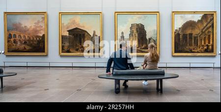 Paris, Frankreich - 05 13 2023: Louvre Museum. Leute von hinten sitzen und schauen sich Gemälde im Museum an Stockfoto
