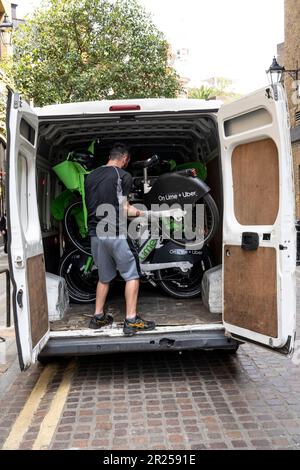 London, Großbritannien. 17. Mai 2023 Ein Techniker in Covent Garden sammelt elektrische Mietzyklen für die Wartung. Im Gegensatz zum Fahrradverleihsystem von Santander, das Fahrradparkplätze vorsieht, verfügen Unternehmen, die die elektrischen Mietzyklen anbieten, wie Lime von Uber, Human Forest und dott, nicht über solche Parkbuchten. Es wurde berichtet, dass Westminster Council Pläne ausarbeitet, um Fahrern, die ihre gemieteten Fahrräder nicht ordnungsgemäß parken, Geldstrafen zu zahlen, und dass Leihfahrräder, die auf Gehwegen zurückgelassen werden, eine Gefahr für Fußgänger und Rollstuhlfahrer darstellen können. Kredit: Stephen Chung / Alamy Live News Stockfoto