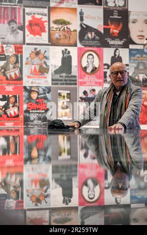 Wiesbaden, Deutschland. 17. Mai 2023. Filmregisseur Volker Schlöndorff steht in der Ausstellung „Volker Schlöndorff. Von Wiesbaden zur Welt" vor Filmposten. Die Ausstellung in der FilmBühne Caligari zeigt Publikationen und Filmserien über das Leben und Werk des preisgekrönten Filmemachers vom 19. Mai bis 18. Juni 2023. Kredit: Arne Dedert/dpa/Alamy Live News Stockfoto