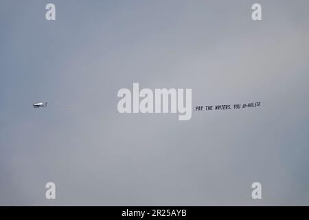 Los Angeles - 15. Mai 2023: Ein kleines Flugzeug zieht während des WGA-Streiks der Writers Guild of America ein Banner und liest: "PAY THE WRITERS, YOU AI-HOLES!" Stockfoto